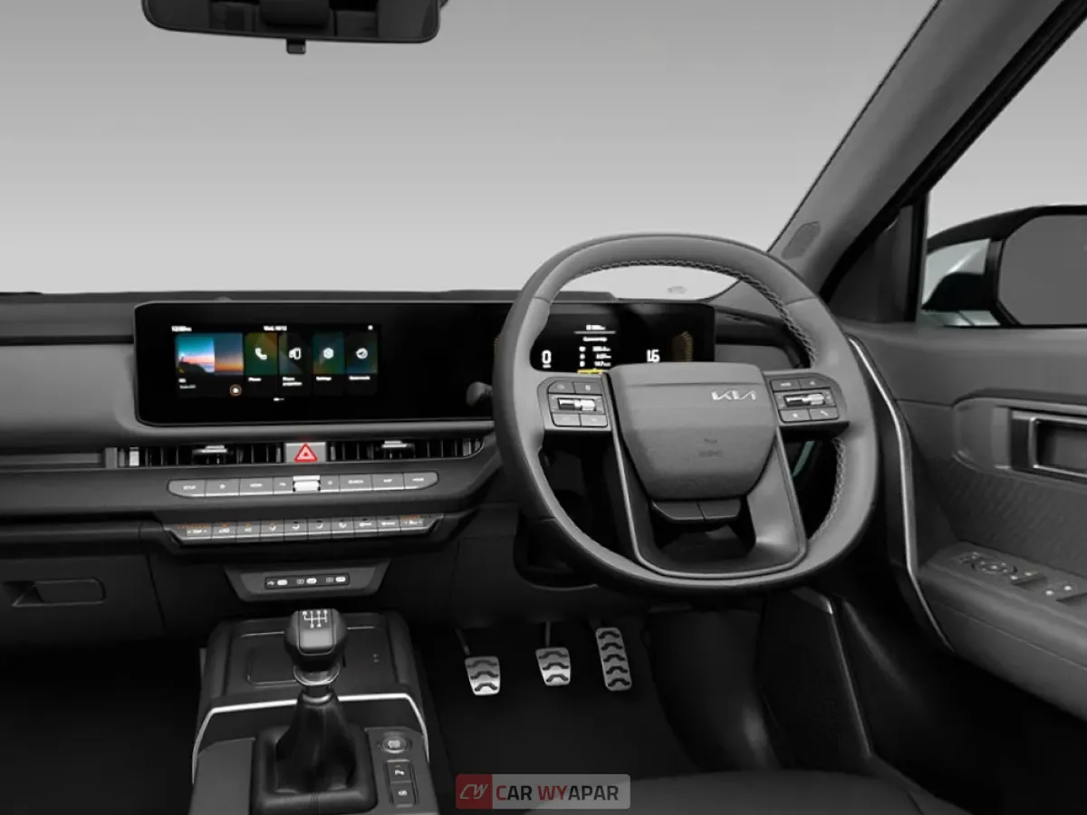 A black-and-white interior view of the Kia Seltos HTX (O) variant, showing the steering wheel, dual-screen dashboard, and manual transmission shifter.